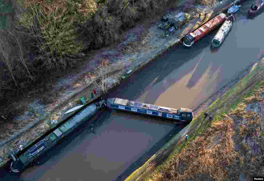 A drone view shows a canal boat lying across the partly drained canal after a section of the Bridgewater Canal embankment collapsed during heavy rain near Little Bollington, Britain.