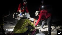 In this photo provided by the Ukrainian Emergency Service, rescuers unblock the body of a civilian who was killed when a Russian drone hit a city food factory in Mykolaiv, Ukraine, Jan. 29, 2025. 