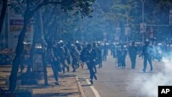 Opposition protesters, center, run from riot police and tear gas at a demonstration in Nairobi, Kenya, Sept. 26, 2017.