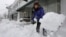 Alisa Riley, shovels snow from a sidewalk in front of a fitness center where she works in Scituate, Massachusetts, Jan. 22, 2014. 