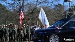 Des employés du Service des Parcs Nationaux dans le comté de Sumter saluent le cortège transportant le cercueil de l'ancien président Jimmy Carter devant la ferme Boyhood, le 4 janvier 2025, à Plains, en Géorgie. (Reuters)