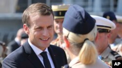 French President Emmanuel Macron shakes hands with French military personnel at the naval base during his second day of visit in Abu Dhabi, United Arab Emirates, Thursday, Nov. 9, 2017. 