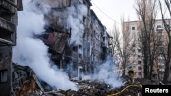 Un bombero trabaja en el lugar de un edificio residencial destruido en un ataque con misiles rusos, en Selydove, región de Donetsk, Ucrania, el 14 de febrero de 2024.