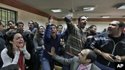 Egyptian protesters chant anti-military ruling slogans during a trial of employees of pro-democracy groups charged with using foreign funds to foment unrest in Cairo, February 26, 2012. 