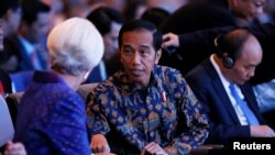 Direktur IMF Christine Lagarde (kiri) bersama Presiden Joko Widodo pada pertemuan IMF-Bank Dunia di Bali.