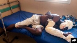 FILE — Saga Saganla, 30, from Diawely, lies on his bed at Somine Dolo hospital in Mopti, Mali, June 24, 2022. Saganla survived an attack by 100 jihadis on motorbikes. Human rights groups have documented cases of “war crimes” against civilians in Burkina Faso and Mali as well.