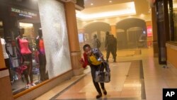 Una mujer que había permanecido escondida aprovecha para escapar durante los enfrentamientos en el centro comercial de Nairobi.