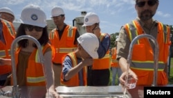 FILE - People taste recycled wastewater at the Edward C. Little Water Recycling Facility during the West Basin Municipal Water District's tour of a water recycling facility in El Segundo, California, July 11, 2015. More than 80 percent of wastewater worldwide is released without treatment, contaminating rivers and lakes, a U.N. report finds.