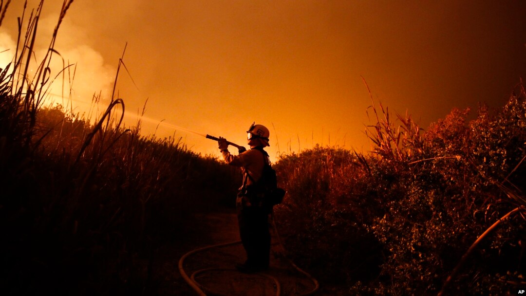 Firefighter Ryan Spencer battles a wildfire as it burns along a hillside toward homes in La Conchita, California, Dec. 7, 2017. 