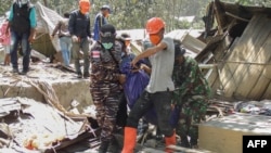 Members of a rescue team carry away bodies in Klatanlo village, in East Flores Regency, East Nusa Tenggara, on November 4, 2024, after Mount Lewotobi Laki-Laki erupted overnight.