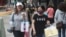为防疫戴口罩的台湾民众走过台北的购物街区。（2020年10月29日）