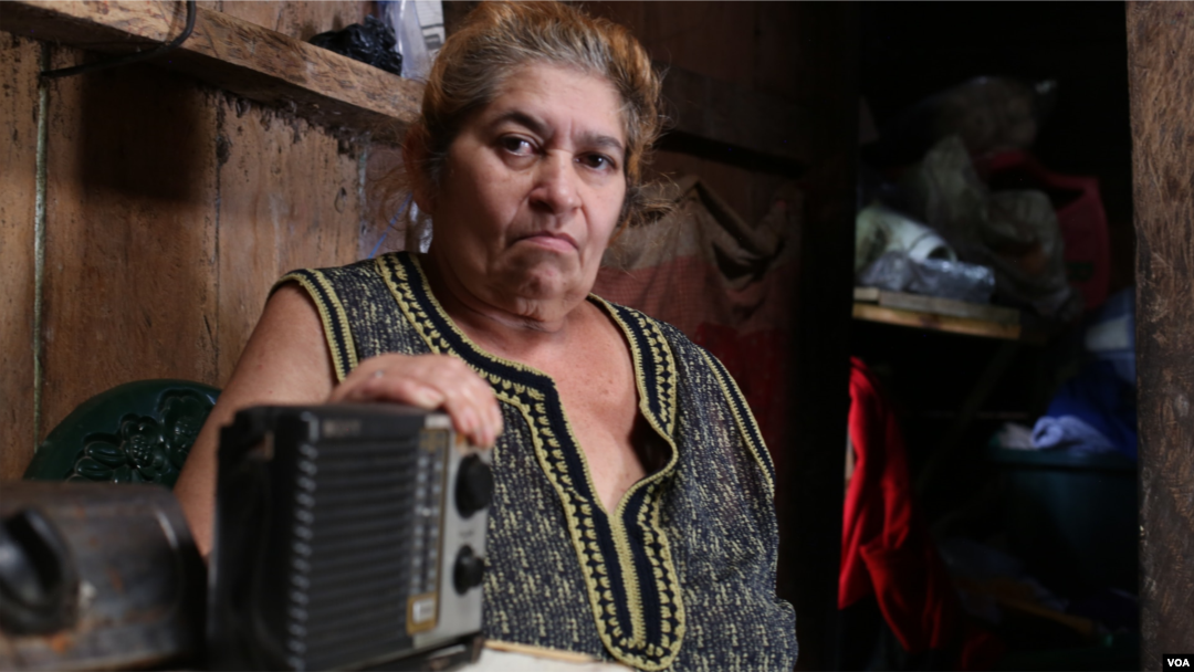Campesina nicaragüense sostiene su radio, su único medio para informarse.