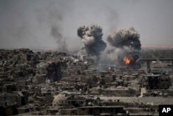 FILE - Airstrikes target Islamic State positions on the edge of the Old City a day after Iraq's prime minister declared "total victory" in Mosul, Iraq. July 11, 2017.