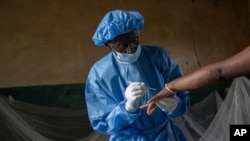 Atumisi Anaclet treats a sex worker with mpox on Sept. 4, 2024, in a hospital in Kamituga, in eastern Congo's South Kivu province.