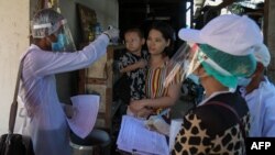 အိမ်တိုင်ယာရောက် ကိုယ်အပူချိန်တိုင်းတာပေးနေတဲ့ ကျန်းမာရေးဝန်ထမ်းတချို့ကို ရန်ကုန်မြို့ရှိ ရပ်ကွက်တခုအတွင်းတွင် တွေ့ရ။ (မေ ၁၆၊ ၂၀၂၀)