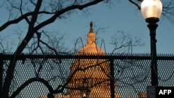 FILE - A security fence topped with concertina wire surrounds the grounds of the U.S. Capitol in Washington, Jan. 19, 2021.