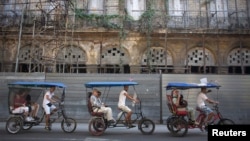 Para turis naik becak di Havana, Kuba (23/1).