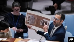 FILE - Jonah Leff of Conflict Armament Research shows photos of debris from weapons used by Russia, found in Ukraine, at the United Nations, June 28, 2024. Findings indicate North Korea made the weapons. Pyongyang is now stepping up its efforts, Leff said Dec. 18.