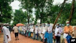 FILE - Rohingya refugees wait to get vaccinated against COVID-19 in Cox's Bazar, Bangladesh, Aug.10, 2021.