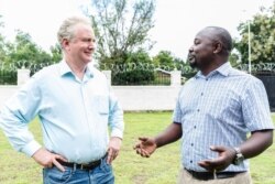 Senator Chris Van Hollen, left, walks with CARE employee while touring refugee settlements in Uganda, Aug. 14, 2019. (Photo: I. Godfrey / CARE)