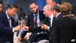 Presiden China Xi Jinping (kiri), Presiden Rusia Vladimir Putin (tengah) dan Presiden Mesir Abdel Fattah el-Sisi bersulang dalam resepsi di sela KTT BRICS di Kazan, Rusia, pada 23 Oktober 2024. (Foto: Alexey Nikolskiy/brics-russia2024.ru via AP)