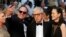 FILE - A guest takes a selfie with director Woody Allen (C) and his wife Soon-Yi Previn as they arrive on the red carpet at the 68th Cannes Film Festival in Cannes, southern France, May 15, 2015.