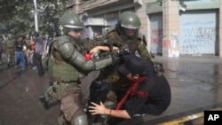 Police detain a man during an anti-government protest in Santiago, Chile, Oct. 26, 2019. Days of unrest have shaken the nation.