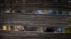 A man wearing a face mask looks through a barrier in a neighborhood in Wuhan, the central Chinese city where the coronavirus first emerged last year, in central Hubei province. 