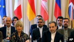 The European Union's Political Director Helga Schmid, front left, and Iran's Deputy Foreign Minister Abbas Araghchi, front right, attend meeting held as part of closed-door nuclear talks with Iran, at a hotel in Vienna, Austria, July 28, 2019.