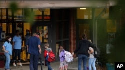 Students arrive to Dallas Elementary School for the first day of school amid the coronavirus outbreak on Monday, Aug. 3, 2020, in Dallas, Ga. (AP Photo/Brynn Anderson)