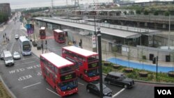 Autobuses frente a una estación de Londres, con el parque olimpico al fondo. 