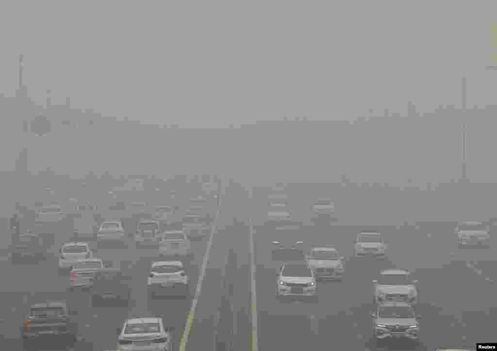 Traffic passes on a road as the sky is enveloped with smog after Delhi&#39;s air quality turned &quot;severe&quot; due to alarming air pollution, in New Delhi, India.