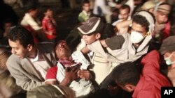 Anti-government protesters carry a wounded fellow protester during clashes with police in the southern Yemeni city of Taiz, May 29, 2011