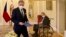 Czech President Milos Zeman, right, sitting in a plexiglass cubicle after testing positive for COVID-19, appoints ODS leader Petr Fiala, left, as Czech prime minister, at the Lany Manor, near Prague, Nov. 28, 2021.