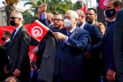 The leader of Tunisia's Islamist Ennahda party, House Speaker Rached Ghannouchi, waves a Tunisian flag during a rally in Tunis, Tunisia, Feb. 27, 2021.