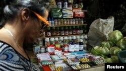 A woman walks past a fruit and vegetables stall selling medicines at a market in Rubio, Venezuela, Dec.r 5, 2017.