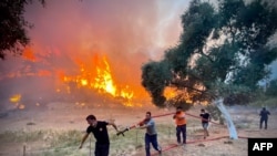 Firemen and local volunteers extinguish a wildfire in Oren, in the vacation region of Mugla, Aug. 6, 2021, as Turkey struggles with its deadliest wildfires in decades.
