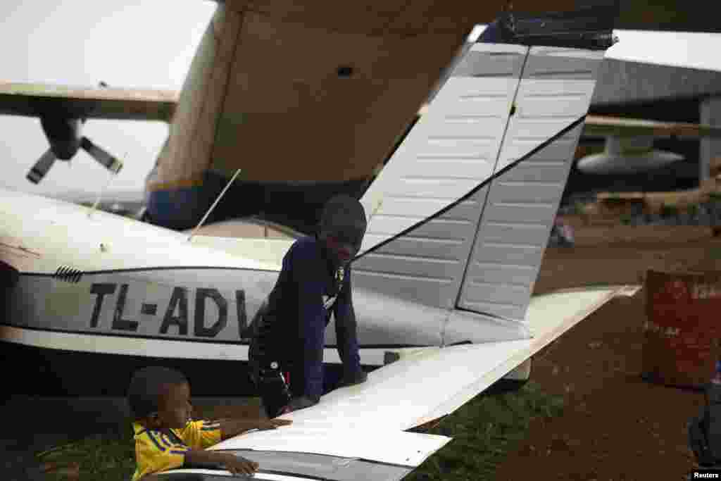 Children stand near broken-down airplanes in a section of the airport being used to shelter Muslims fleeing the latest sectarian violence, Bangui, March 4, 2014. 