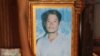 An unknown person holds a photo of Tuy Sros, 34, in a home in Banteay Meanchey province's Ou Chrov district's Chrey village, Phnom Penh, Cambodia, January 20, 2020. (Sun Narin/VOA Khmer) 