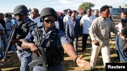 FILE - Members of a security team escort Lesotho politician Thomas Thabane (center, in background) after he cast his vote during the country's national elections in Magkhoakhoeng village, outside the capital Maseru, Feb. 28, 2015. Thabane's estranged wife, Lipolelo Thabane, was shot dead Thursday by unknown assailants. 