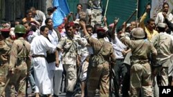 Soldiers hold back supporters of Yemen's President Ali Abdullah Saleh during clashes with anti-government protesters in the southern city of Taiz, Apr 22 2011