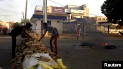 Sudanese protesters erect a barricade along a street during demonstrations in central Khartoum, Sudan, May 15, 2019. 