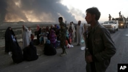 Smoke rises as people flee the clashes between Iraqi security forces and members of the Islamic State group in the area of Mosul, Iraq, Oct. 18, 2016. Amnesty International is asking Iraqi and Kurdish forces not to detain, torture or kill male Sunni civilians.