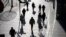 Visitors to a shopping mall cast shadows as they walk through a health check point in Beijing, China, Dec. 14, 2021. 