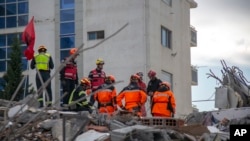 Rescuers from France and Switzerland operate at a collapsed building after the 6.4-magnitude earthquake in Durres, western Albania, Nov. 29, 2019. 