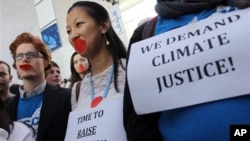 Local and international activists march inside a conferences center to demand urgent action to address climate change at the U.N. climate talks in Doha, Qatar, December 7, 2012.