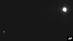 This image captured on Dec. 19, 2018, by a camera on the Osiris-Rex spacecraft shows the asteroid Bennu, top right, about 27 miles (43 kilometers) from the spacecraft, and the Earth and moon, bottom left, more than 70 million miles (110 million kilometers