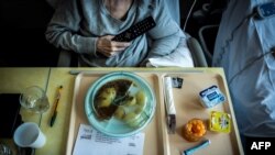 Seorang pasien kanker bersiap menyantap makan siangnya di sebuah rumah sakit di Leon Berard di Lyon, 10 September 2018. (Foto: AFP)