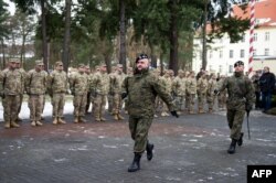 FILE - General Jaroslaw Mika marches before U.S. soldiers during the welcome ceremony at the Polish military base in Zagan, Poland, Jan. 12, 2017.