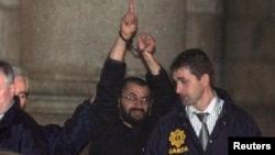 FILE - Ali Charaf Damache, also known by the alias "Black Flag," is accompanied by Irish law enforcement officials as he appears at Waterford District Court to be remanded into custody after being arrested on terrorism charges in Waterford, Ireland, March 13, 2010.